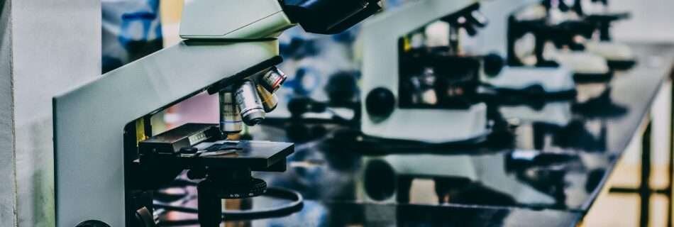 white microscope on top of black table