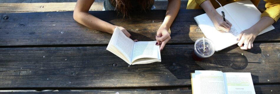 woman reading book while sitting on chair